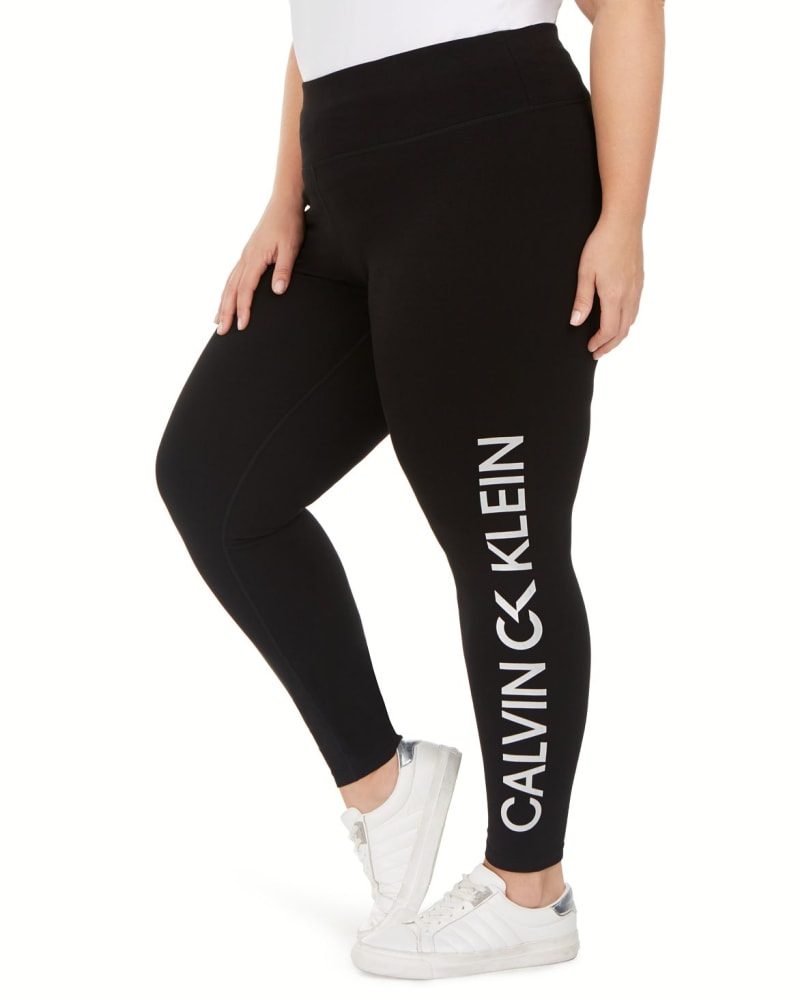 Side of a model wearing a size 3X Calvin Klein Women's Performance Pull on Logo Legging Black 3X in Black by Calvin Klein. | dia_product_style_image_id:308668